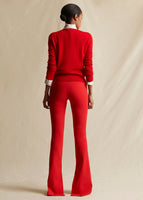 A model standing backwards wearing a red sweater and red pants.