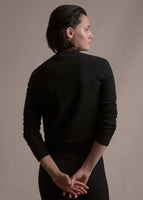 Image of a model facing backwards wearing black crewneck sweater.