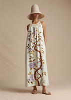 A model wearing the Halter Dress in Printed Crepe paired with the Cleo Hat.