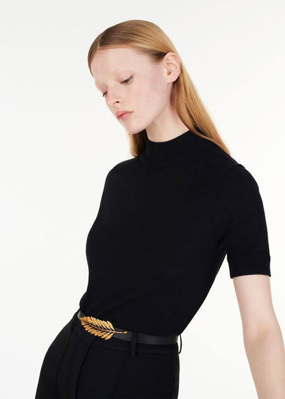 model wearing the gold fern leaf belt with ultra-fine cashmere mockneck in black