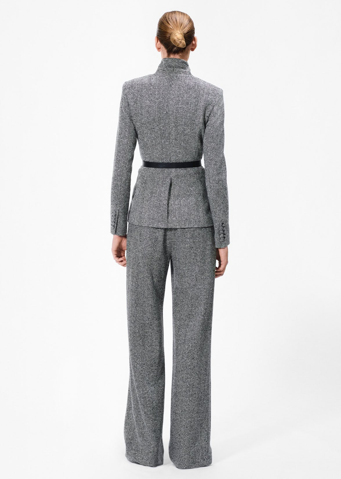 back view of model wearing the full leg trouser in wool herringbone with the spencer jacket 