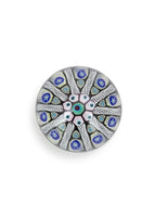 Photo of Millefiori glass paperweight with intricate pattern containing blue, green, and light pink colors.