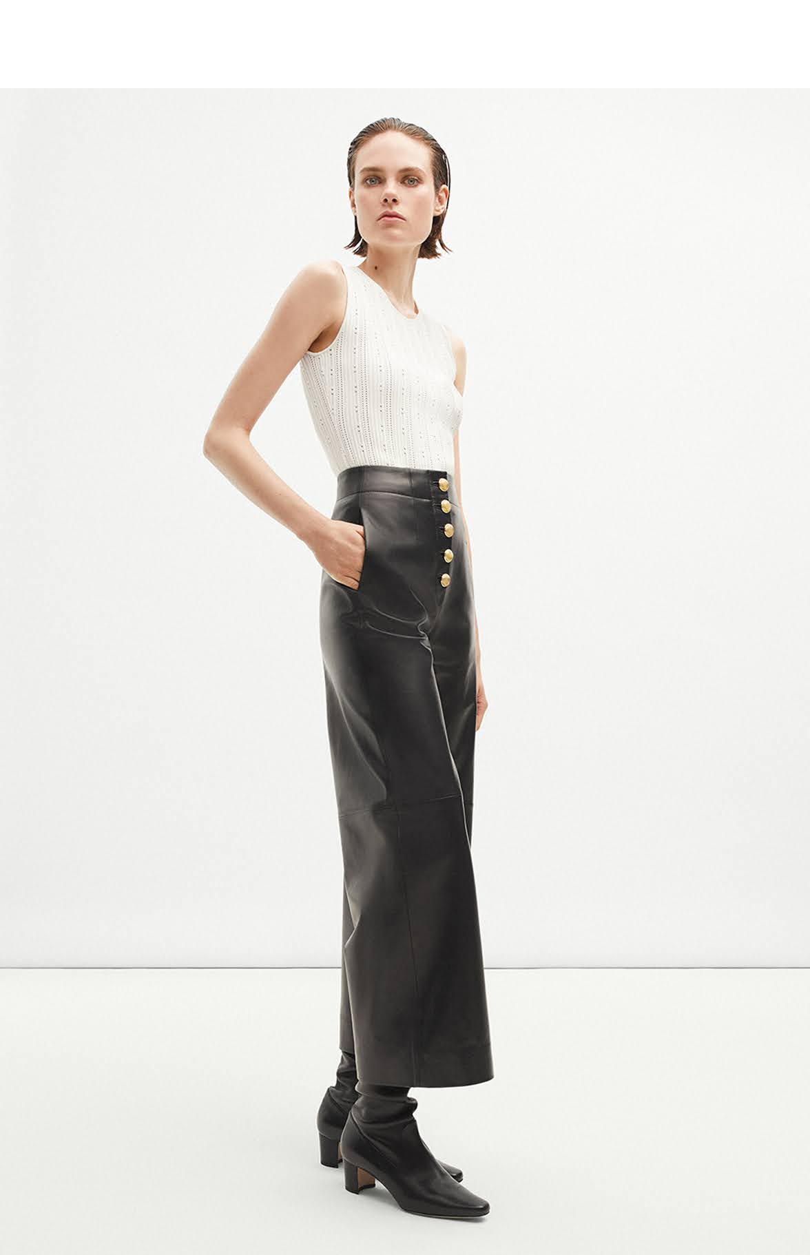 Model wearing the Barclay Pant with Gold Buttons in leather and Brynn Top in Ivory