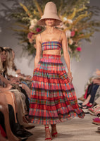 Model is facing forward wearing a full cotton skirt in this season's colorful madras print.  Elastic smocking at the waist.