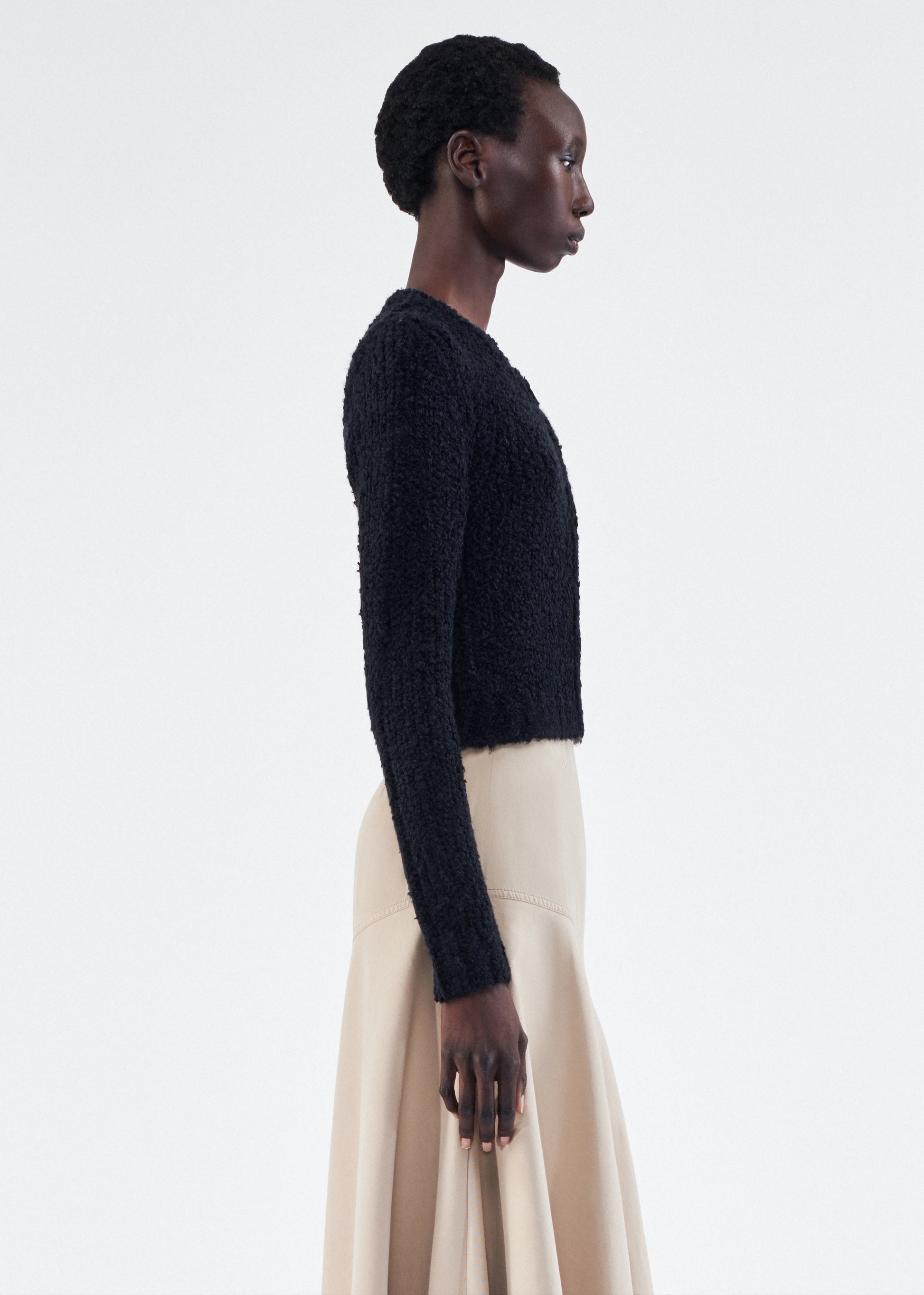 Side of model is wearing the Alice Cardigan in Mulberry Silk in Black