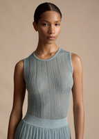 Close up image of a model wearing the Shell in Metallic Rib in Pale Blue, paired with the Tiered Skirt in Metallic Rib in Pale Blue.