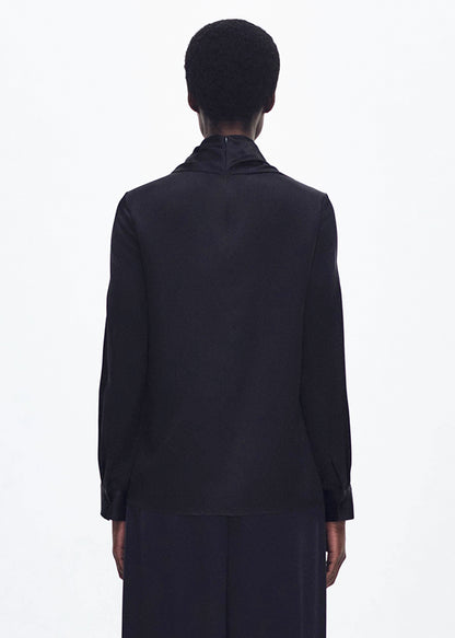 back profile of model wearing the bandera blouse in silk in black