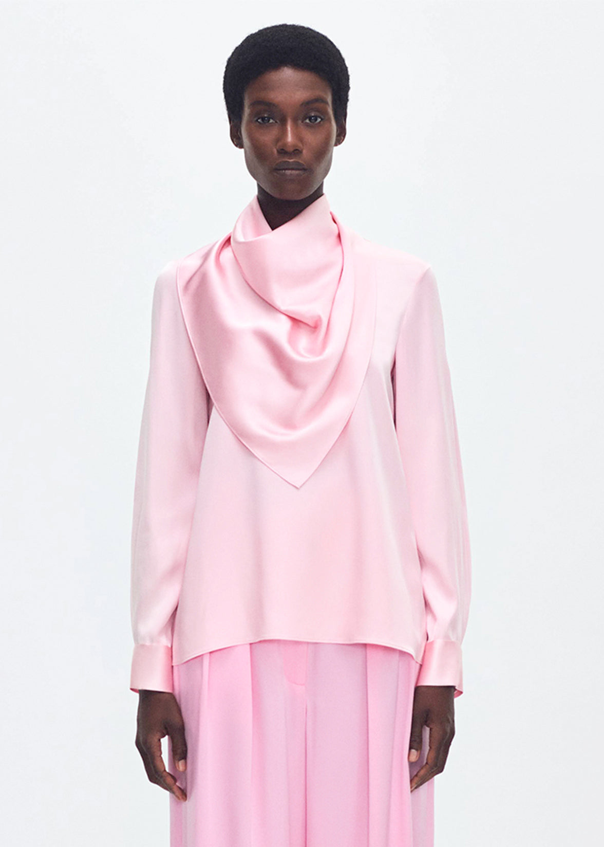 Model wearing the Bandera Blouse in Silk Charmeuse in Pink with a pink skirt