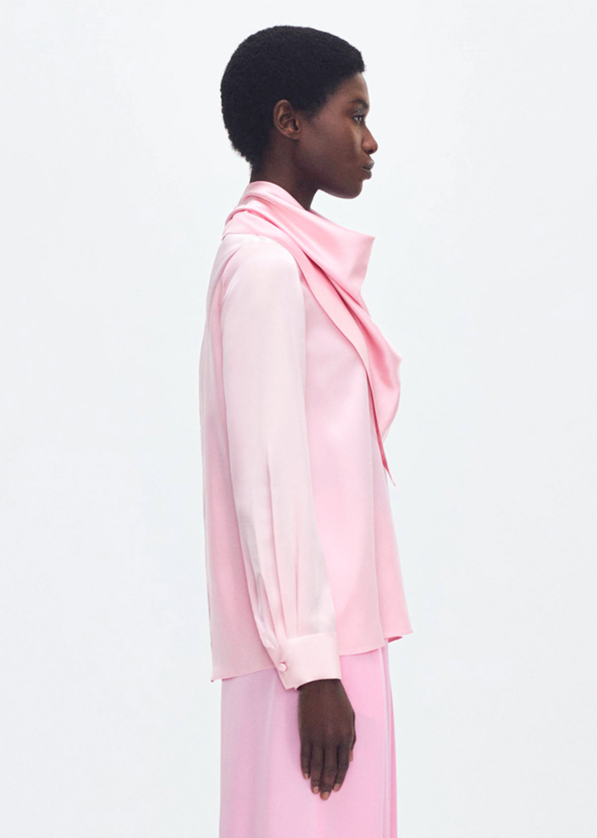 Model wearing the Bandera Blouse in Silk Charmeuse in Pink with a pink skirt