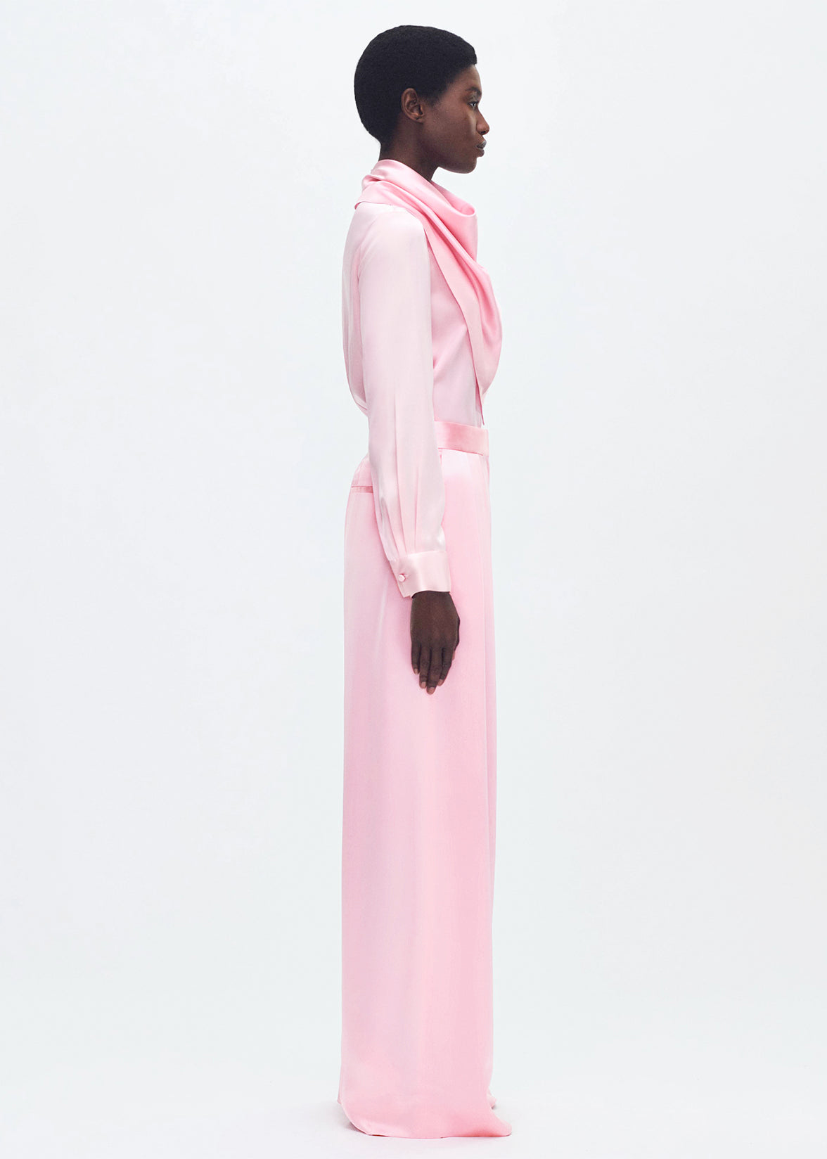 Side-facing model wearing the nils pant in pink silk charmeuse