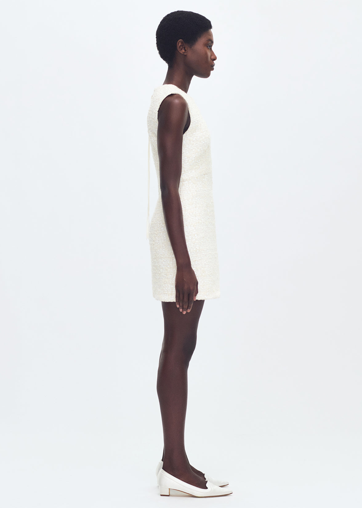 side full body profile of model wearing the tati dress in tweed in ivory