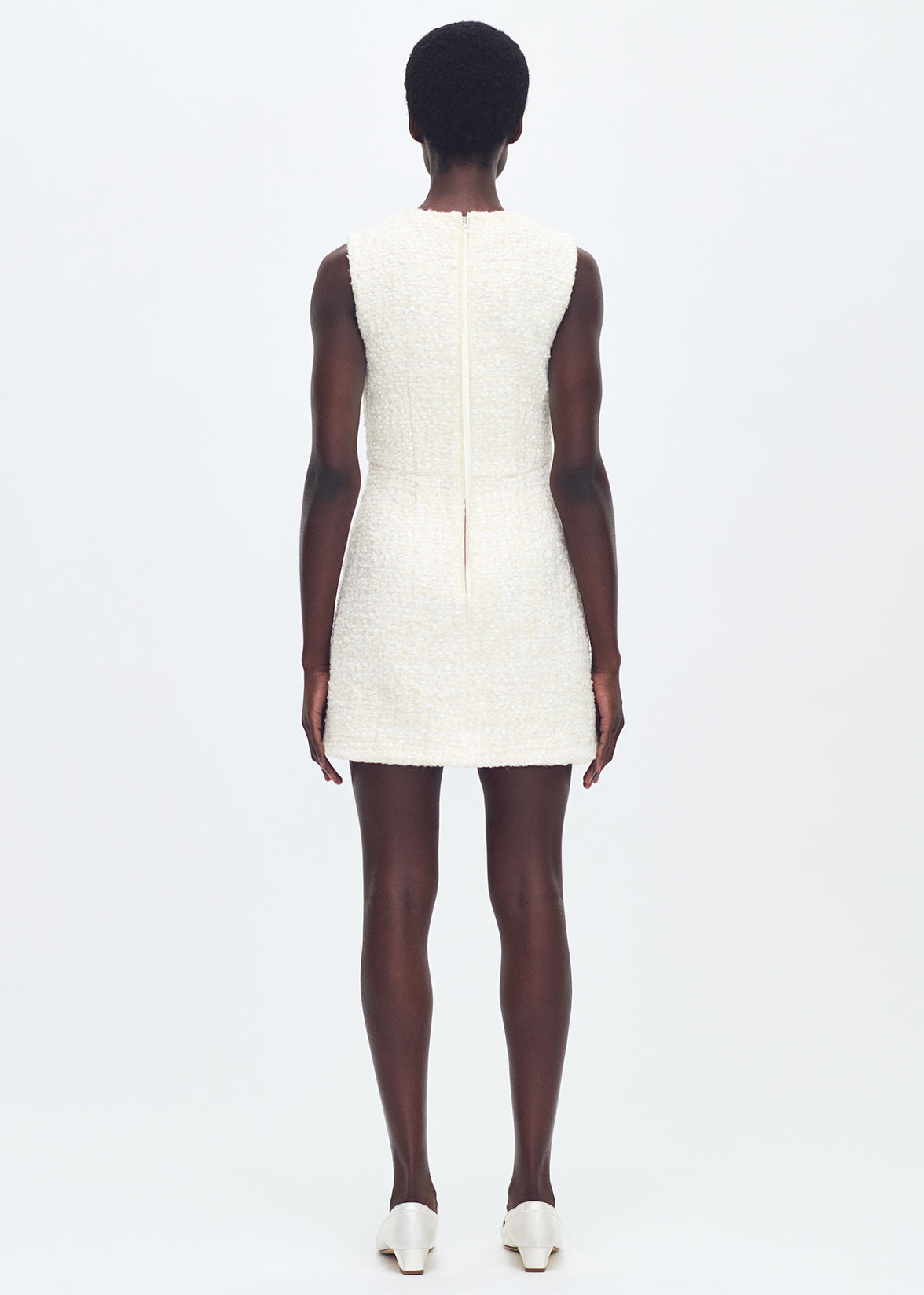 back full body profile of model wearing the tati dress in tweed in ivory