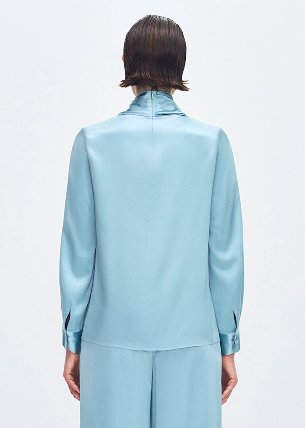 back profile of model wearing the bandera blouse in silk in mist