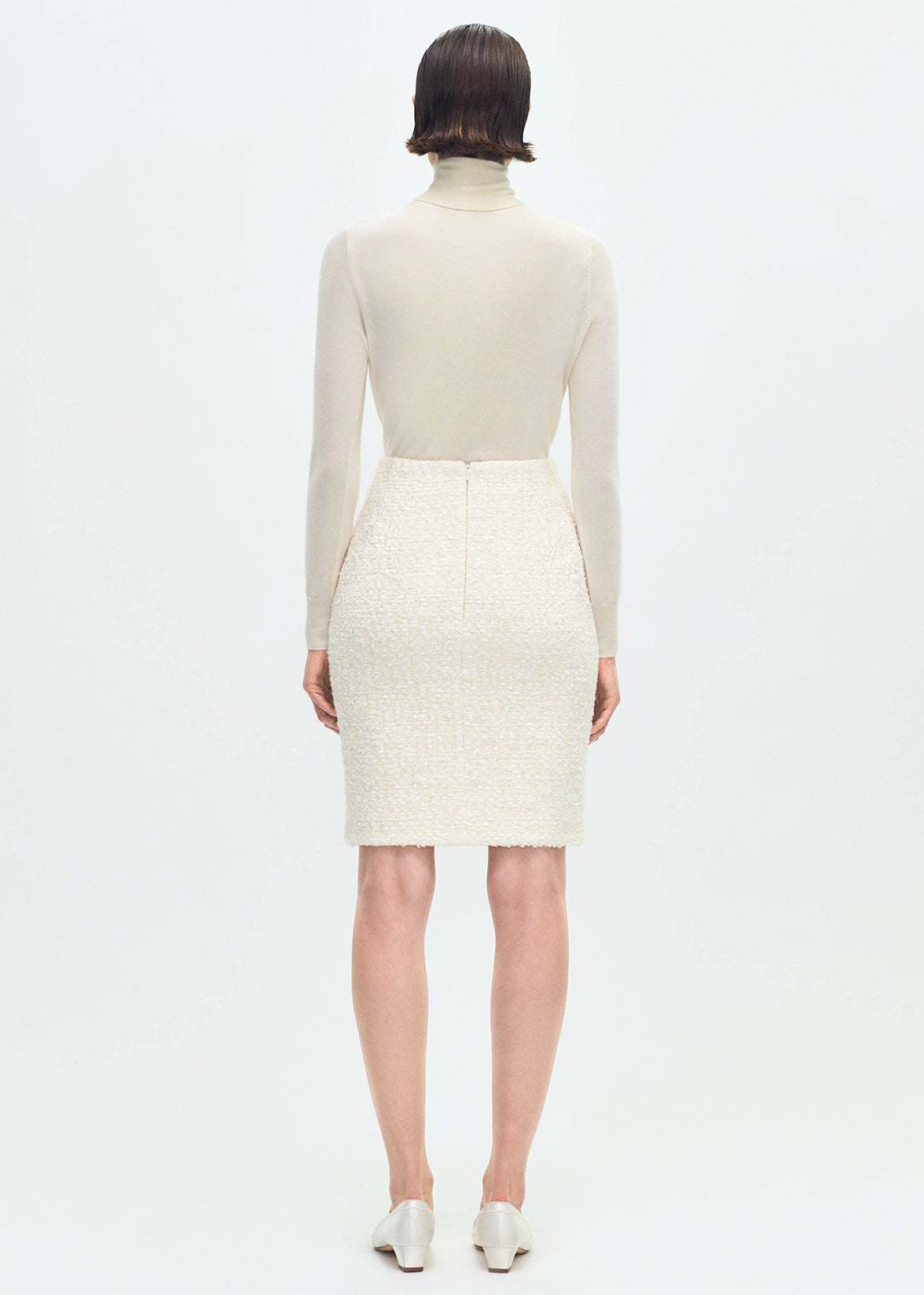 back profile of model wearing the Blair Skirt in Tweed in Ivory