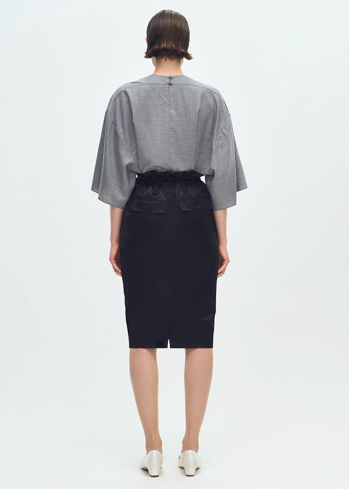 Back profile of model wearing the Sullivan Skirt in Silk Cotton Duchesse