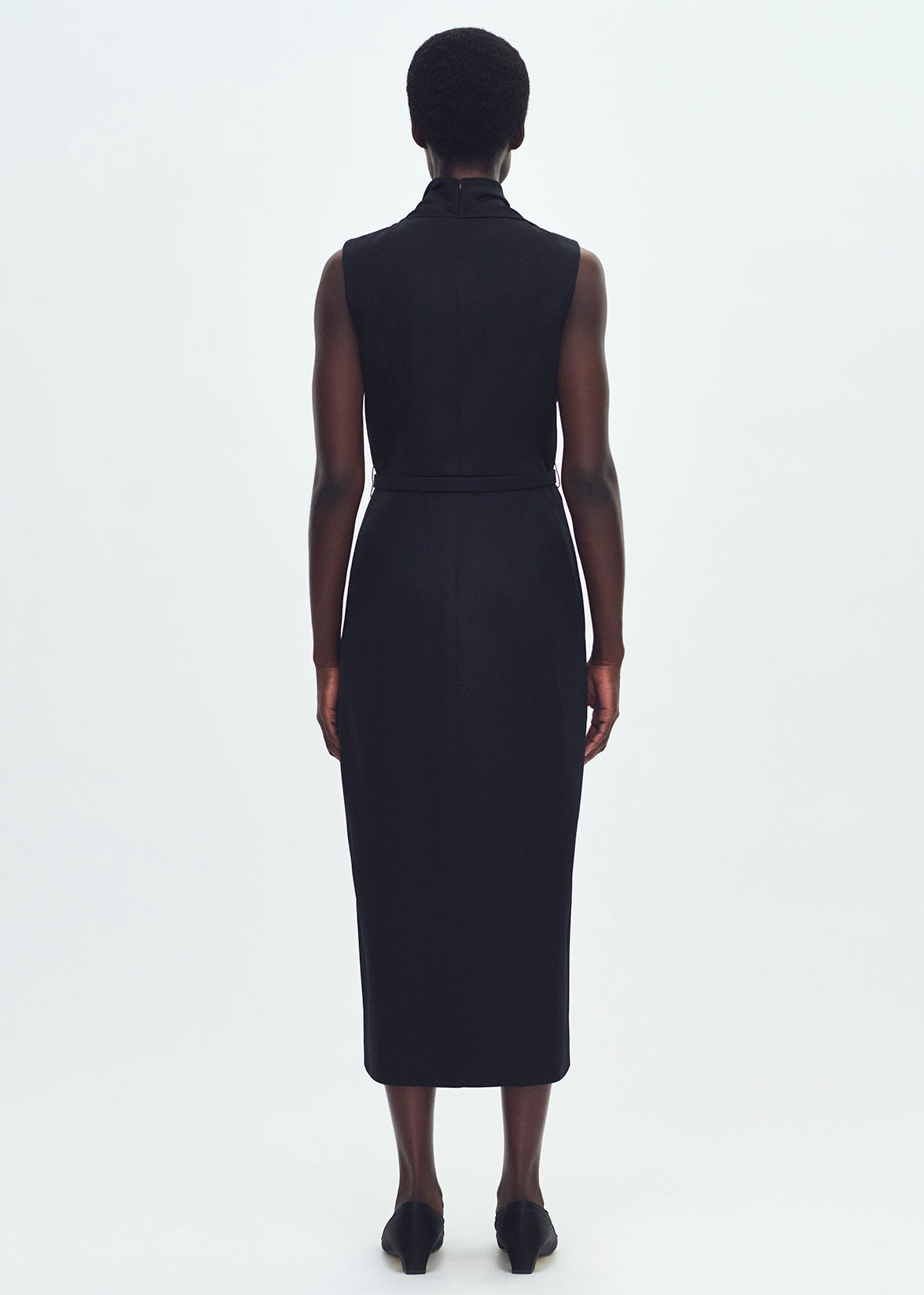 Back profile of model wearing THE BANDERA DRESS IN SILK CREPE IN
BLACK