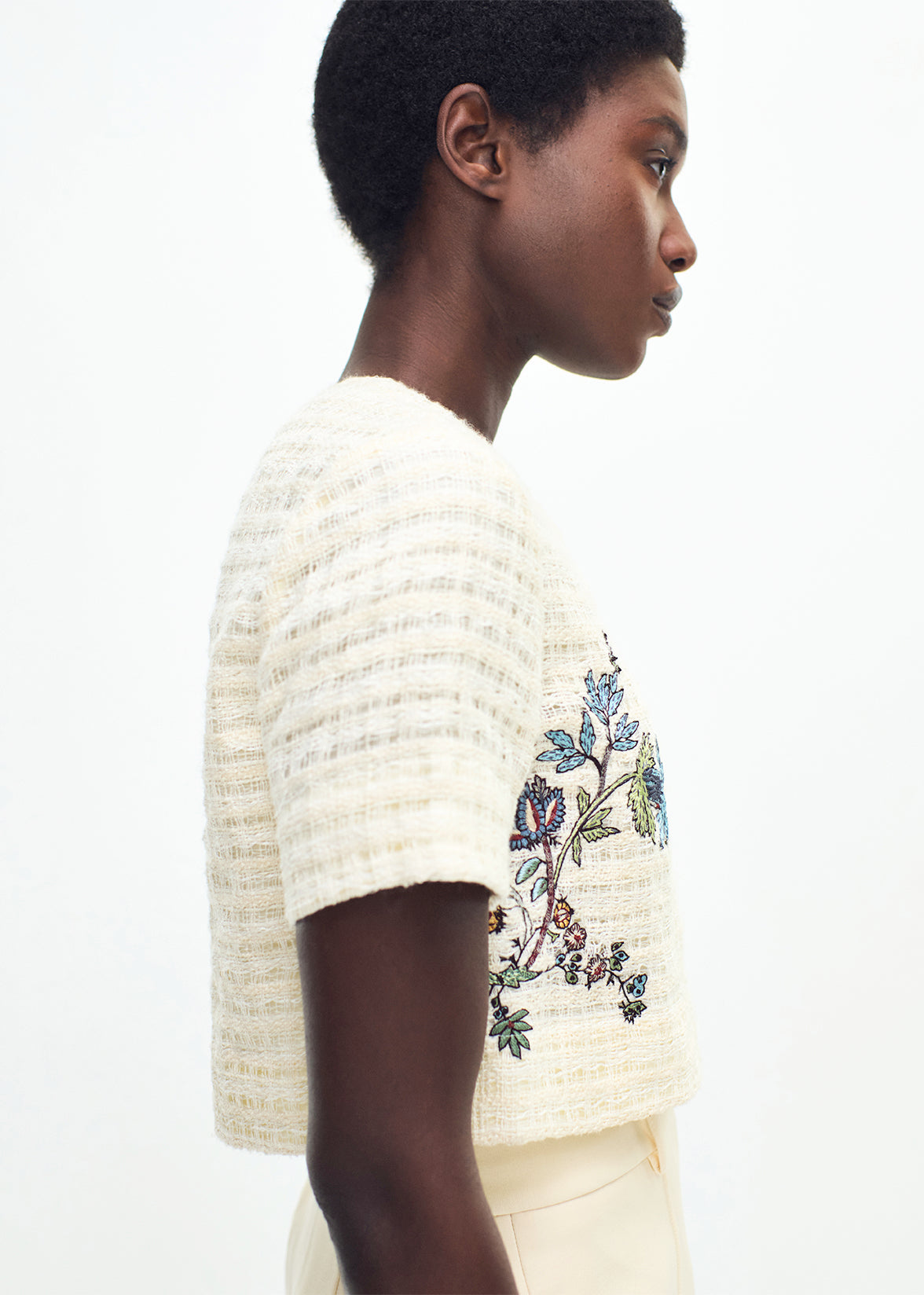 close up of model wearing the embroidered jacket in basketweave in ecru multi