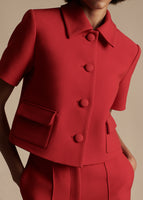 Model is wearing the Cropped Marseille Jacket in Vermillion. The fabric is silk wool.