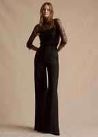 Image of a model in the black Deeda Pant in silk wool paired with the Chantilly Lace Turtleneck in black.