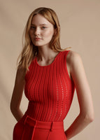 Model is wearing the sleeveless Pointelle Knit Shell in Vermillion.