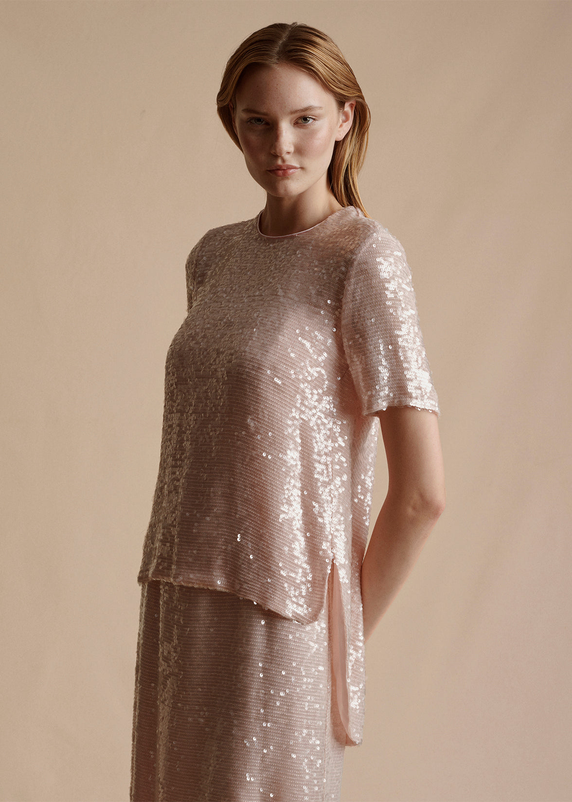 The model is wearing the Cross Back T-Shirt in embroidered blush sequins by Adam Lippes