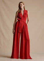 Model is wearing the sleeveless, floor-length Nansi Jumpsuit in Silk Crepe in Vermillion. 