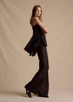 Model is wearing the black Cami Top with fringe in silk crepe, paired with the black Bettina Pant in wool. Photo is a side view to show the fringe.