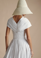 An image of the back of the Sibyl Dress in Cotton Poplin, paired with the Cleo Hat.