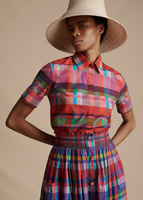A close up image of a model wearing the Trapeze Shirt in Printed Voile, paired with the Cleo Hat and the Lovisa Skirt with Smocked Waist in Printed Voile.