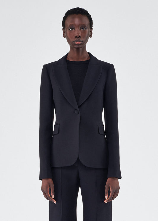 An image of a model wearing the single breasted blazer in silk wool in black by Adam Lippes