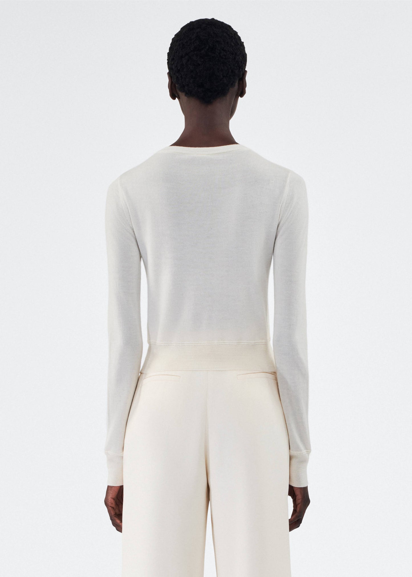 back view of model wearing the adam lippes cardigan in cashmere silk in ivory