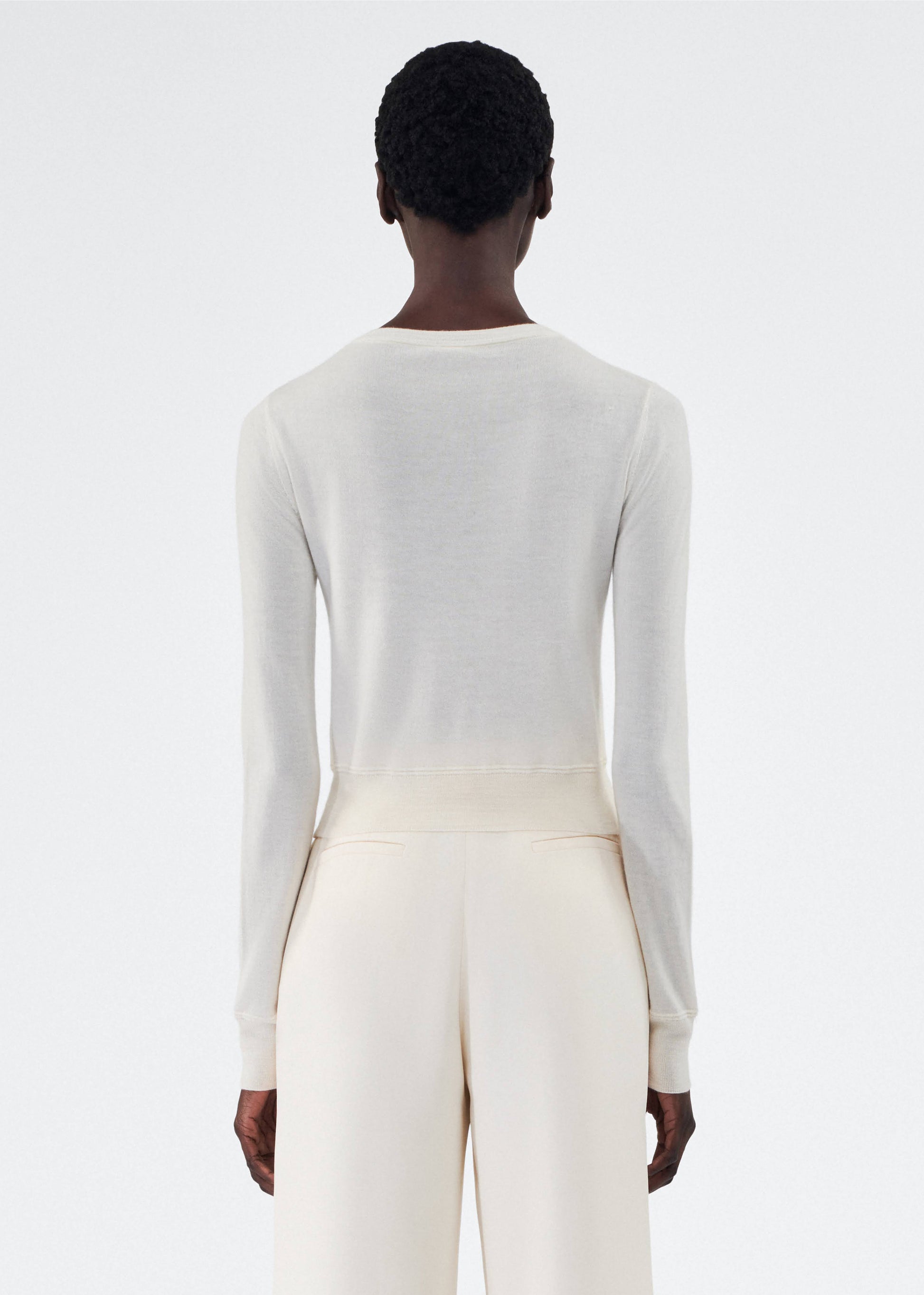 back view of model wearing the adam lippes cardigan in cashmere silk in ivory