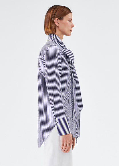 side view of model wearing lee blouse by adam lippes in striped poplin in navy and white