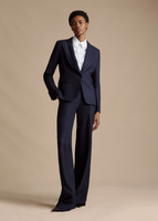 An image taken from further away of a model wearing the Single Breasted Blazer in Stretch Canvas, paired with the Full Leg Trouser in Stretch Canvas and the Shirt with Thin Bow.