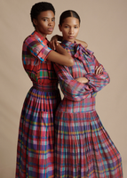 An image of two models standing next to one another, one wearing the Sigrid Dress in Madras Chiffon and the other wearing the Trapeze Shirt in Printed Voile with the Lovisa Skirt with Smocked Waist in Printed Voile.