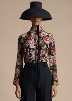 A model wearing the Shirt with Thin Bow in Printed Crepe de Chine, paired with the Deeda Pant in Silk Wool and Taiko Hat.