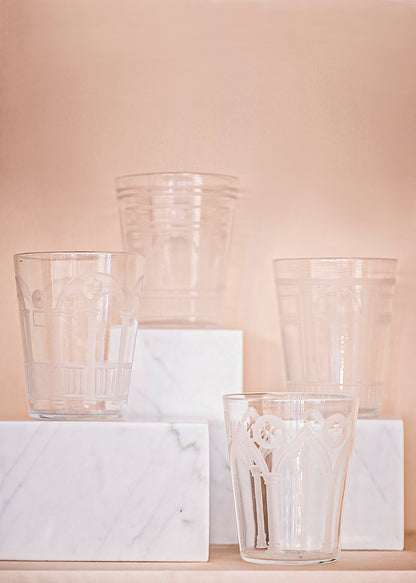 Four crystal cups in front of a pale pink background