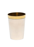 An image of a silver cup with a gold rim. 