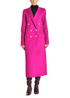 A front-facing image of a model wearing a hot pink coat with gold buttons and tall brown boots.