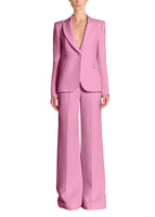 A model wearing a pair of pink pants and a matching pink blazer.