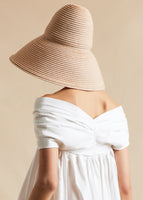 A model turned to the back, wearing a sand colored oversized bucket hat.
