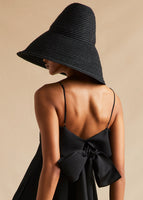 A model wearing a black oversized bucket hat, turned to the back.