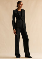 A model wearing a black linen suit, full body.