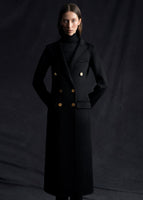 An image of a model wearing a buttoned black cashmere coat with gold buttons.