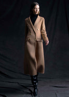 A model wearing a camel color double breasted coat.