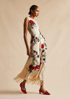 A side view campaign image of a model wearing a red, floral, embroidered, midi dress. 