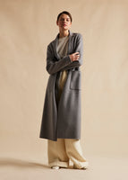 A model wearing a grey zibeline cashmere coat with patch pockets.