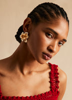 A model wearing a white flower earring.