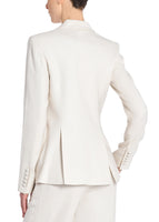 A back view image of a model wearing an ivory, double breasted blazer. 