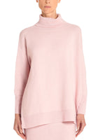 A model wearing a pink sweater.
